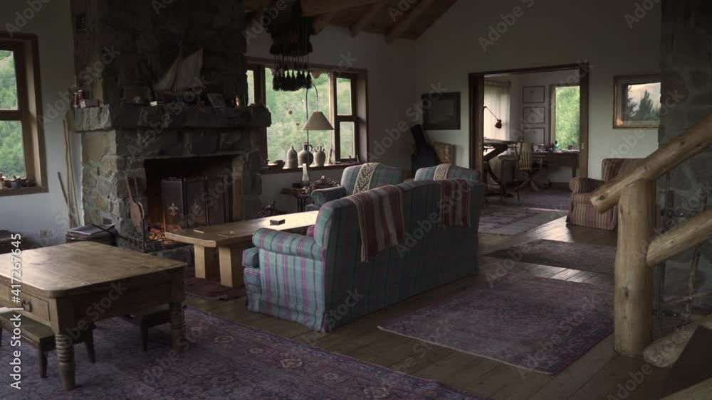 Cozy and elegant large living room with sofas, hearth, little table and nature view windows in big wooden house Slow Motion and 60fps Cozy and elegant large living room with sofas, hearth, little table and nature view windows in big wooden house Slow Motion and 60fps