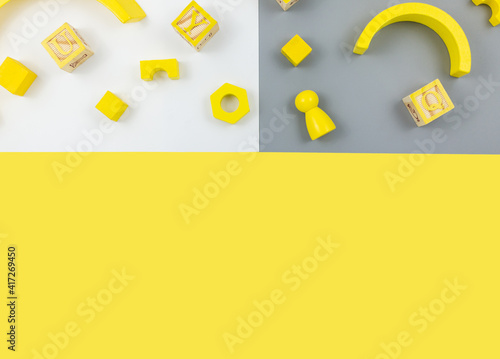 Wooden toys, blocks  on yellow gray background. Trendy cute baby first toys. Eco-friendly, plastic-free set of accessories for kids. Toys for kindergarten, preschool or daycare. Close up	