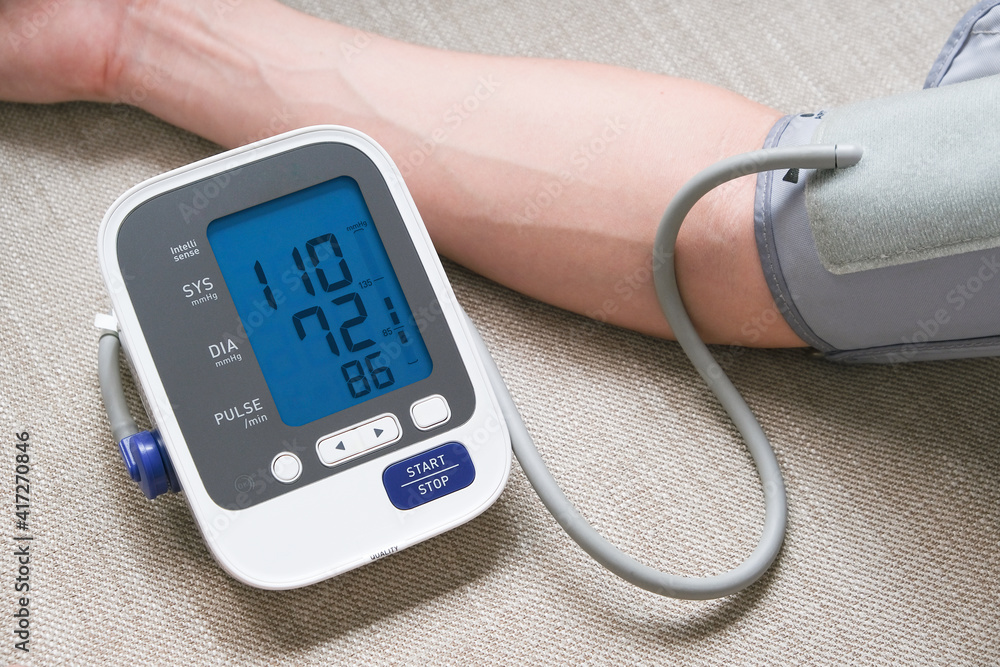 Man check blood pressure monitor and heart rate monitor with digital pressure gauge. Health care and Medical concept Man check blood pressure monitor and heart rate monitor with digital pressure gauge. Health care and Medical concept