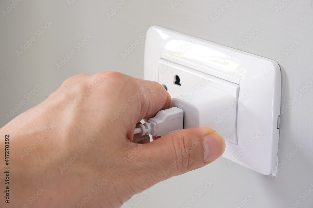 Hand of Electrical Appliances He was pulling the plug. Out of the plug. In his office during work hours. Energy Saving Concepts and Technologies. Hand of Electrical Appliances He was pulling the plug. Out of the plug. In his office during work hours. Energy Saving Concepts and Technologies.