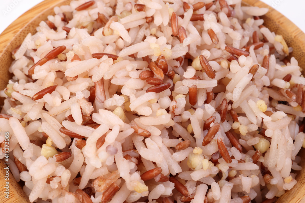 Cooked mixed low glycaemic index healthy rice grain basmati millet buckwheat red rice in wooden bowl on white background Cooked mixed low glycaemic index healthy rice grain basmati millet buckwheat red rice in wooden bowl on white background