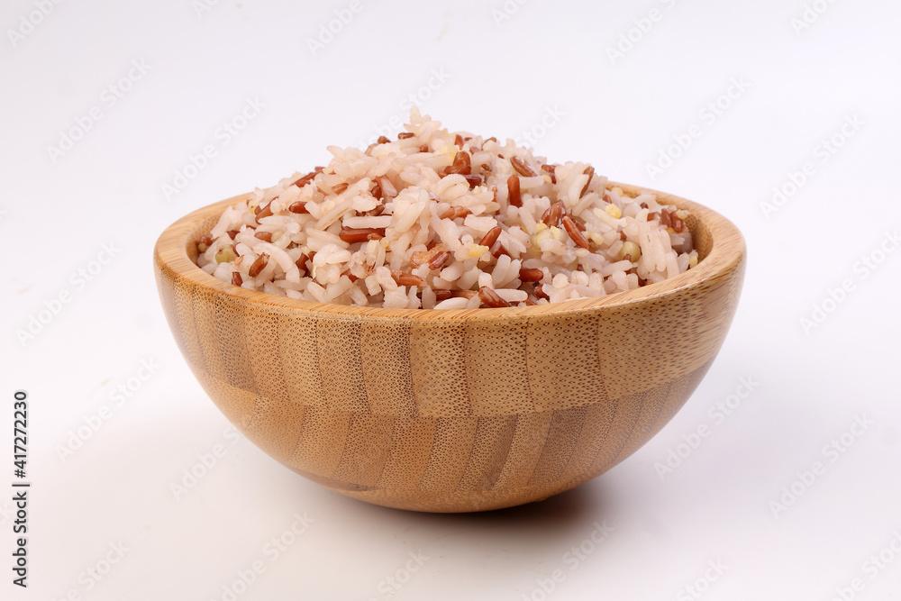 Cooked mixed low glycaemic index healthy rice grain basmati millet buckwheat red rice in wooden bowl on white background Cooked mixed low glycaemic index healthy rice grain basmati millet buckwheat red rice in wooden bowl on white background