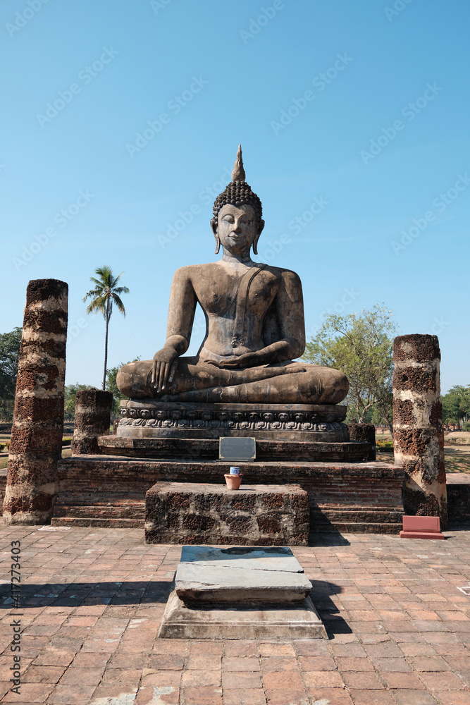 Fototapeta premium Ruins of ancient temples, only bricks and old Buddha statue in the Sukhothai Historical Park.