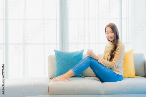 Portrait beautiful young asian woman with coffee cup on sofa decoration