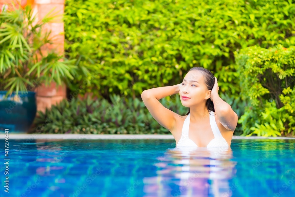 Portrait beautiful young asian woman relax smile enjoy leisure around swimming pool