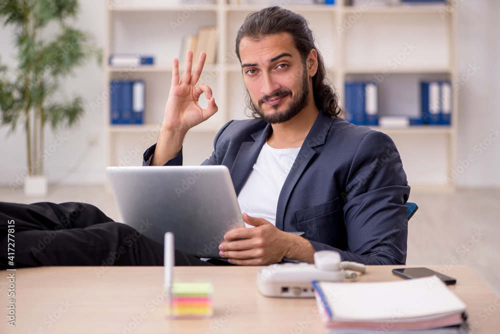 Naklejka premium Young male employee working in the office