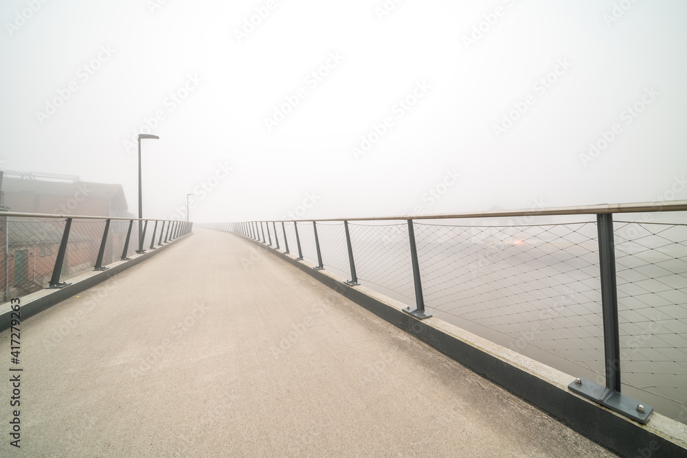 bicycle pedestrian bridge with fog