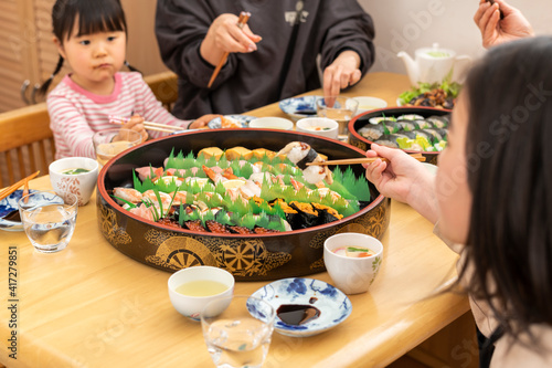 自宅で出前寿司を食べる家族