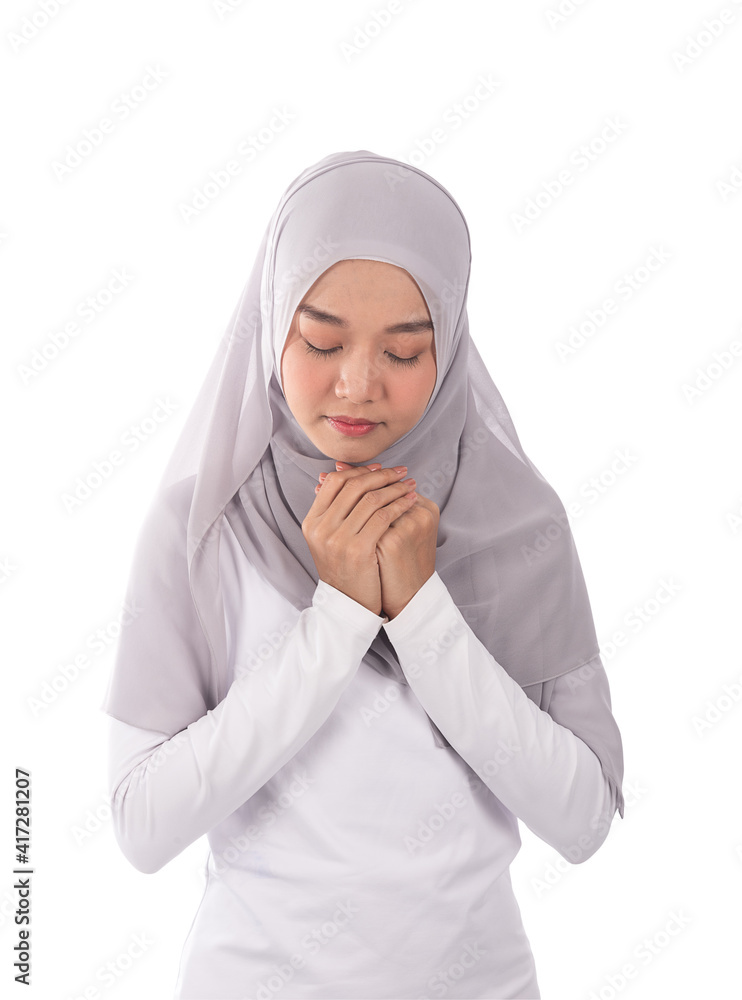 Portrait of Muslim woman in cool earth tone hijab and traditional clothes praying for Allah by close her eyes, isolated white background. Portrait of Muslim woman in cool earth tone hijab and traditional clothes praying for Allah by close her eyes, isolated white background.