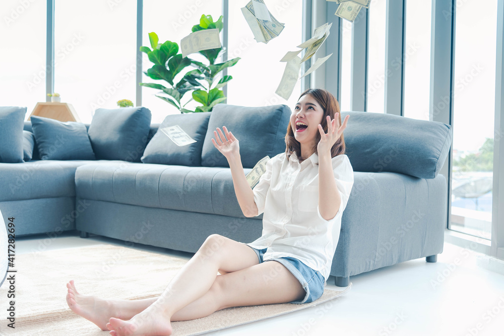 Happy young asian woman holding dollar money and throw in the air celebrate happiness dance wealth lottery money rain drop. Winner Success business woman throw cash flow Happy money smiling face Happy young asian woman holding dollar money and throw in the air celebrate happiness dance wealth lottery money rain drop. Winner Success business woman throw cash flow Happy money smiling face