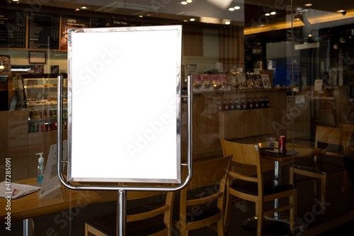 Mockup white poster or white paper promotion displayed on the front of the restaurant, coffee shop promotion information for marketing announcements and details