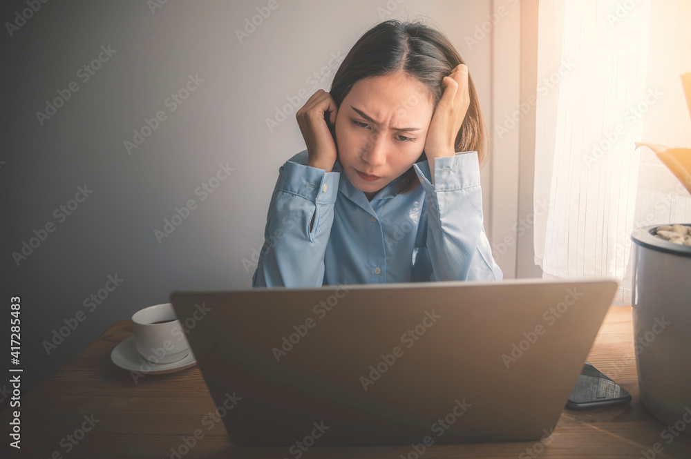 Asian businesswomen working with stress on laptops indoors, work from home. Asian businesswomen working with stress on laptops indoors, work from home.