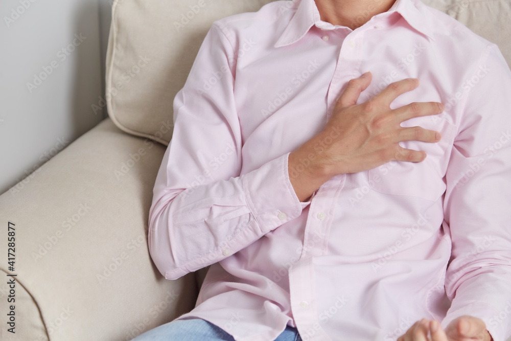 A man has heart attack signs and symptoms during working at home. A man has heart attack signs and symptoms during working at home.