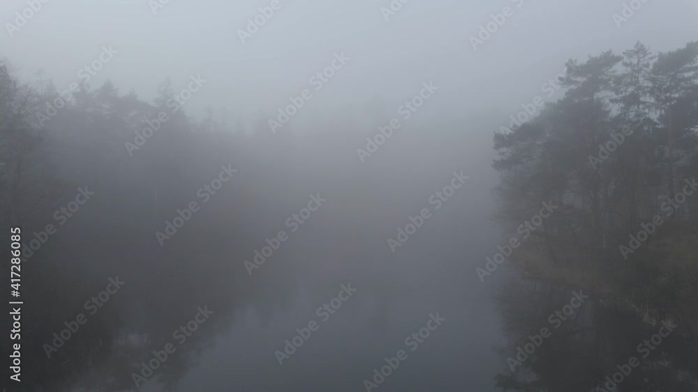 Low aerial of Beautiful mist covered lake surrounded by forest Low aerial of Beautiful mist covered lake surrounded by forest