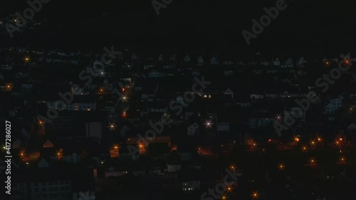 A city at night in aerial view with twinkling lights and a smooth zoom out of the cityscape scenery. photo