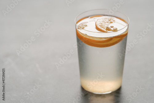 organic lemonade in tumbler glass on concrete background with copy space