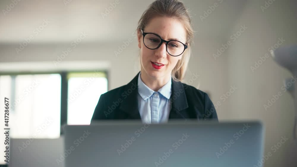 A businesswoman in glasses and a jacket conduct a video conference on a laptop while working from home. A young woman school teacher working from home using her laptop. A businesswoman in glasses and a jacket conduct a video conference on a laptop while working from home. A young woman school teacher working from home using her laptop.