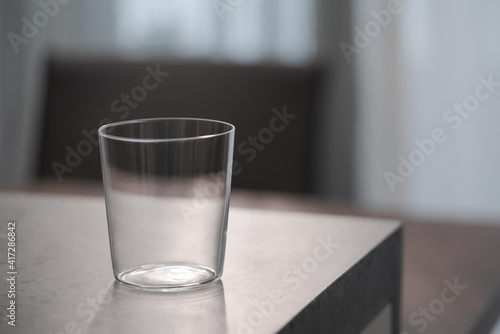 thin tumbler glass on concrete countertop with copy space photo