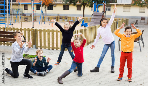 Active kids moving during acting game at city street and having fun