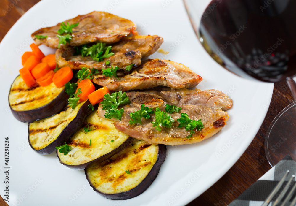 Juicy slices of mutton with grilled eggplant and carrot on plate