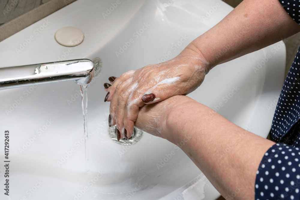 a woman washes her hands over the sink, close-up without a face a woman washes her hands over the sink, close-up without a face