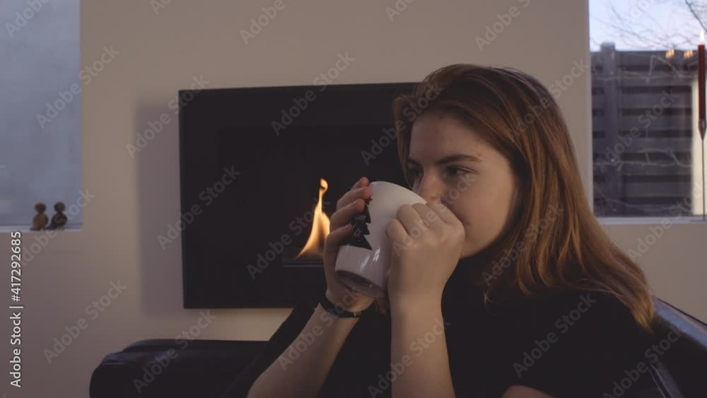 Teenage Girl Relaxing By Fire With Hot Drink Teenage Girl Relaxing By Fire With Hot Drink