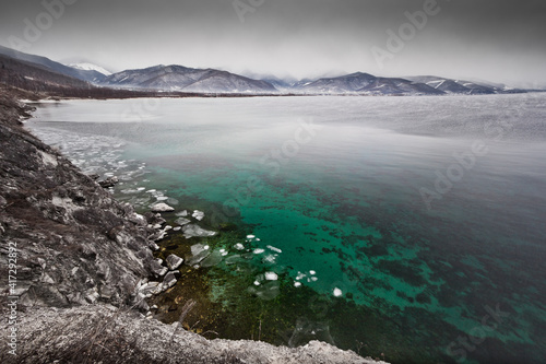Wallpaper Mural Icy coast, green clear water and mountains in the distance, Lake Baikal in late autumn Torontodigital.ca