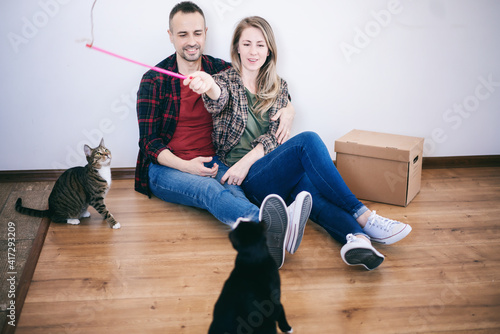 Canvas Print Beautiful happy adult married couple sitting on the floor in the apartment playi