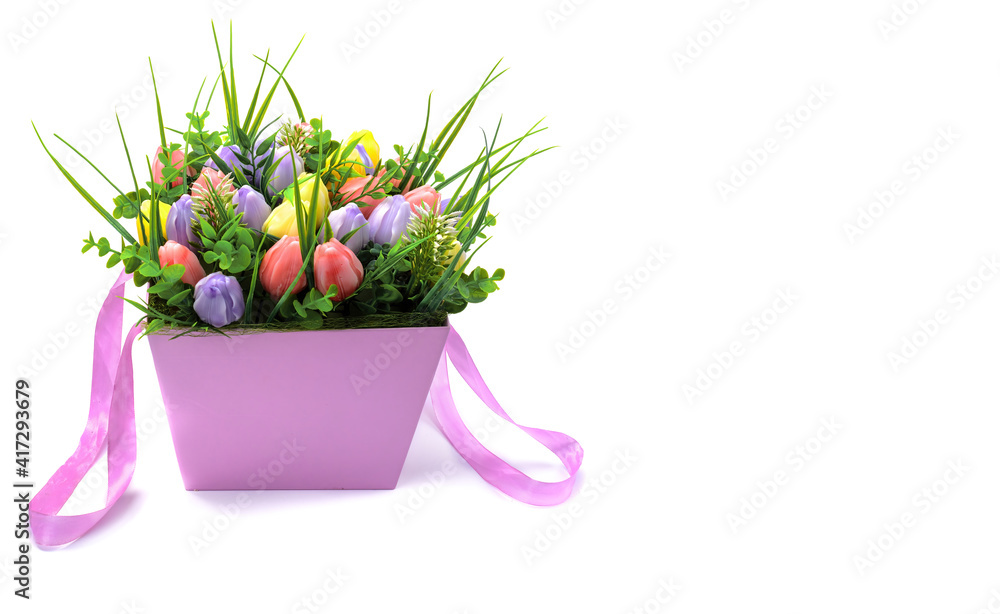 A beautiful bouquet of flowers made of natural soap in a pink paper gift box is isolated on a white background.space for the text.