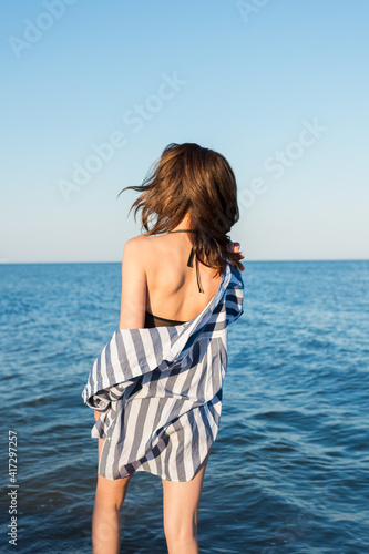 Girl in a striped shirt on the background of the sea.
