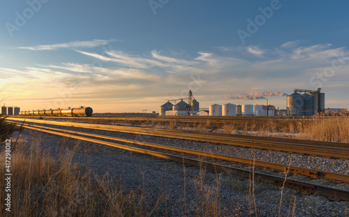 Ethanol production in the Upper Midwest. Ethanol plant located along a rail line with tanker rail cars are lined up nearby.
