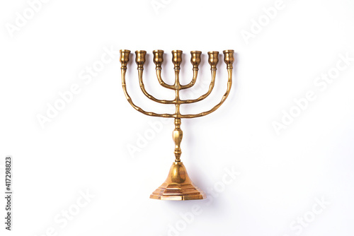 Golden hanukkah menorah on isolated on white background. Jewish holiday banner with copy space. Ancient ritual religious candle menorah photo