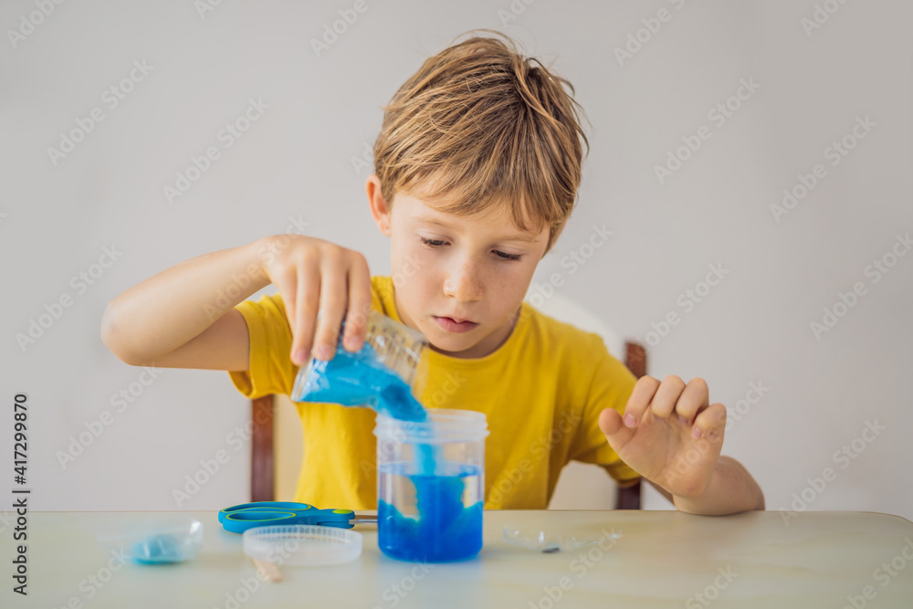 Chemical home tests. Tools for the home lab. the boy Explorer. Child is watching a chemical reaction. The young chemist doing scientific experiments. physical experiment inside Chemical home tests. Tools for the home lab. the boy Explorer. Child is watching a chemical reaction. The young chemist doing scientific experiments. physical experiment inside