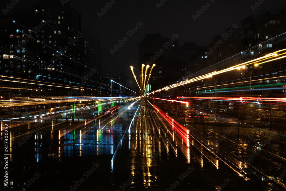Night city scene with zoom effect making colorful stripes and reflections