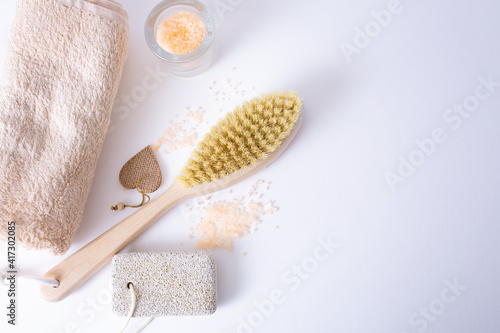 Bath accessories made of natural material, a set of zero waste for the bathroom, soap, cream, sea salt, a wooden brush on a white table. SPA treatments for youth and beauty.
