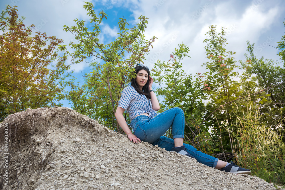 prety woman sit in sand in quarry. enjoy time in summer vacation