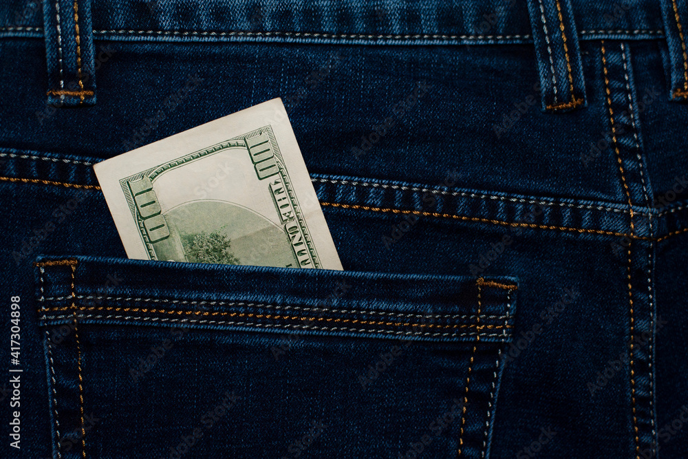 money in your pocket. dollar bills in jeans pocket. The concept of pocket money. Cash. American money, 100 dollar bills. Business, trade or financial transactions, seasonal discounts. close-up money in your pocket. dollar bills in jeans pocket. The concept of pocket money. Cash. American money, 100 dollar bills. Business, trade or financial transactions, seasonal discounts. close-up