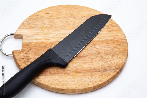 Luxury black kitchen knife on chopping board isolated on white 