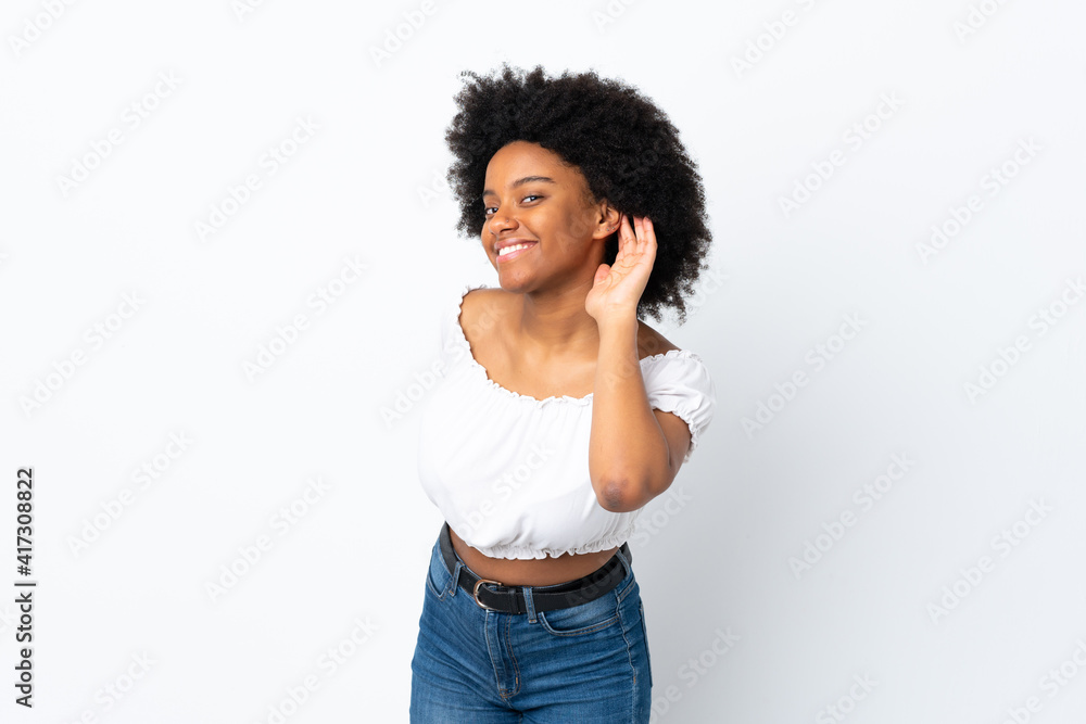 Young African American woman isolated on white background listening to something by putting hand on the ear Young African American woman isolated on white background listening to something by putting hand on the ear