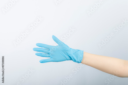Fototapeta Naklejka Na Ścianę i Meble -  Human hand wearing blue latex medical glove