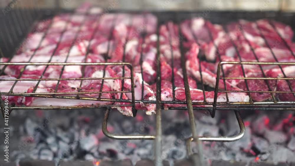Cooking Ribs Over Open Fire Lamb ribs cooked over an open fire, close-up in 4K. Lamb chops Grilling ...