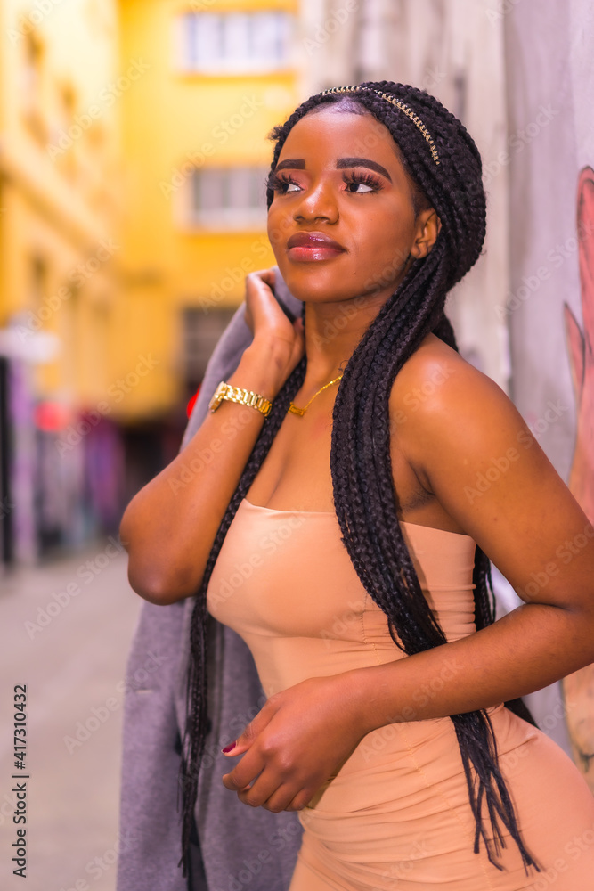 Trendy urban style with a black African girl in a cream colored dress on a  city street Stock Photo by Unai82