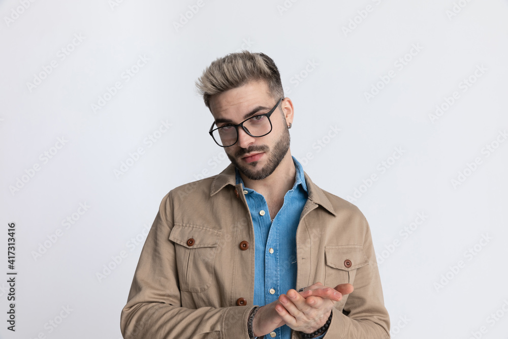 happy young man in denim shirt smiling and rubbing palms