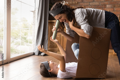 Loving happy young Latino mother and little biracial teen daughter feel playful at family weekend at home. Smiling Hispanic mom and small 8s girl child play funny pirates game. Entertainment concept. photo