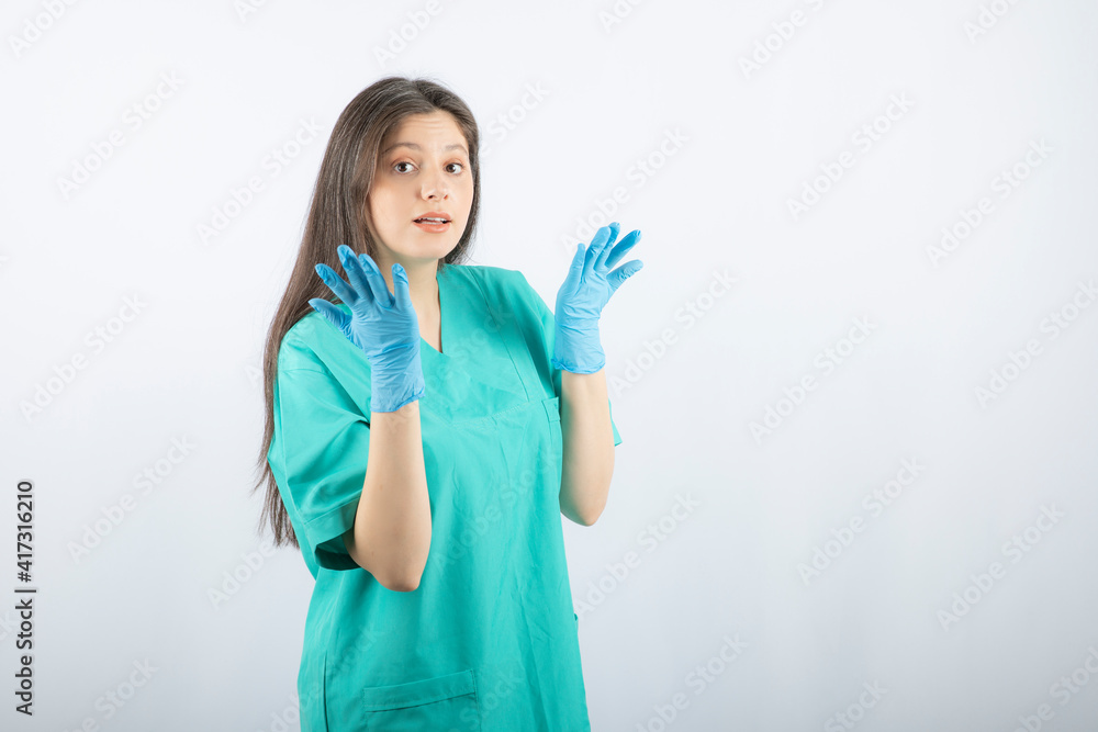 Female doctor in medical gloves showing hands on white background Female doctor in medical gloves showing hands on white background