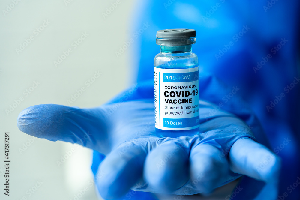 Medical concept ampoules or vials with Covid-19 vaccine on a laboratory bench. Medical concept ampoules or vials with Covid-19 vaccine on a laboratory bench.