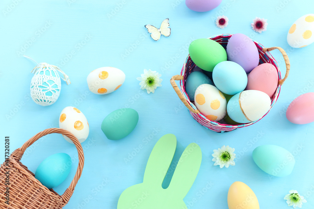 Cute bunny next to easter colorful eggs over pastel background Cute bunny next to easter colorful eggs over pastel background