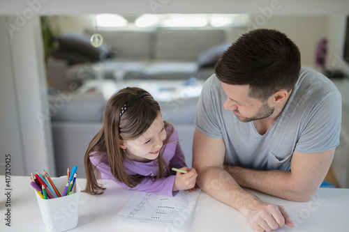 Father helping daughter with homework photo