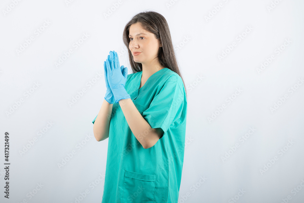 Female doctor in medical gloves showing hands on white background Female doctor in medical gloves showing hands on white background