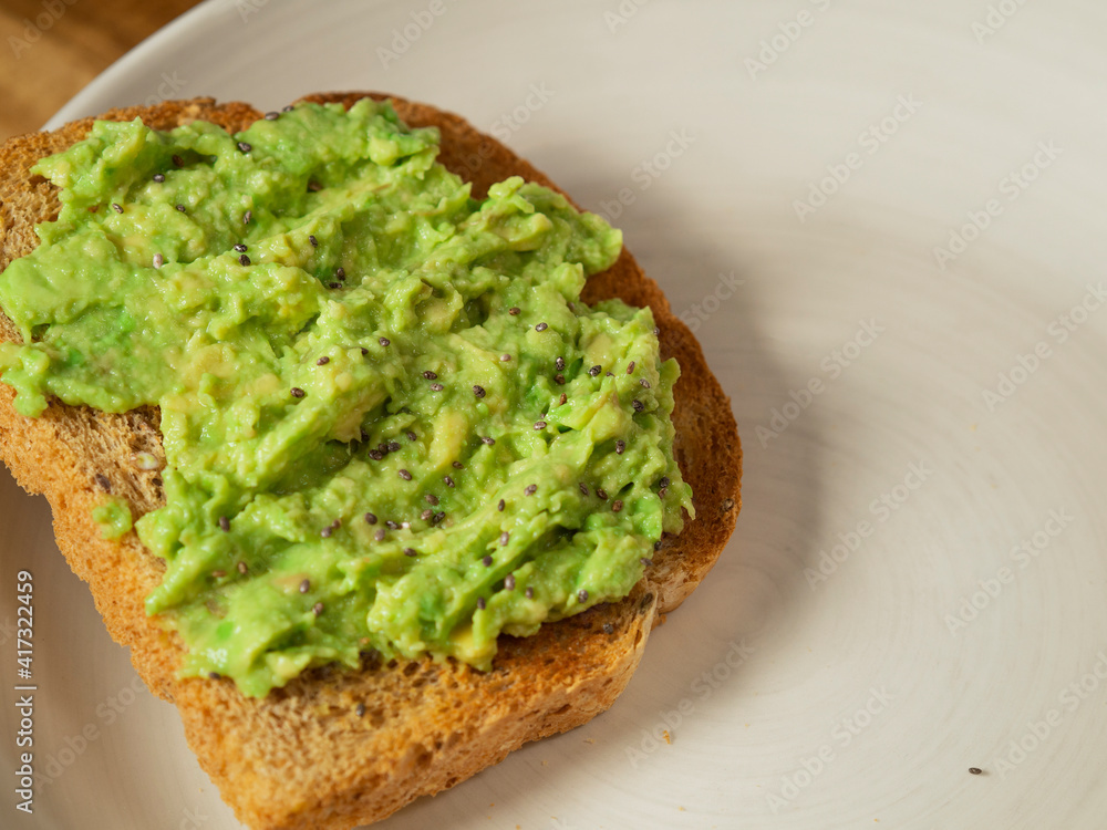 toast with avocado on a white plate. healthy breakfast. toast with avocado on a white plate. healthy breakfast.